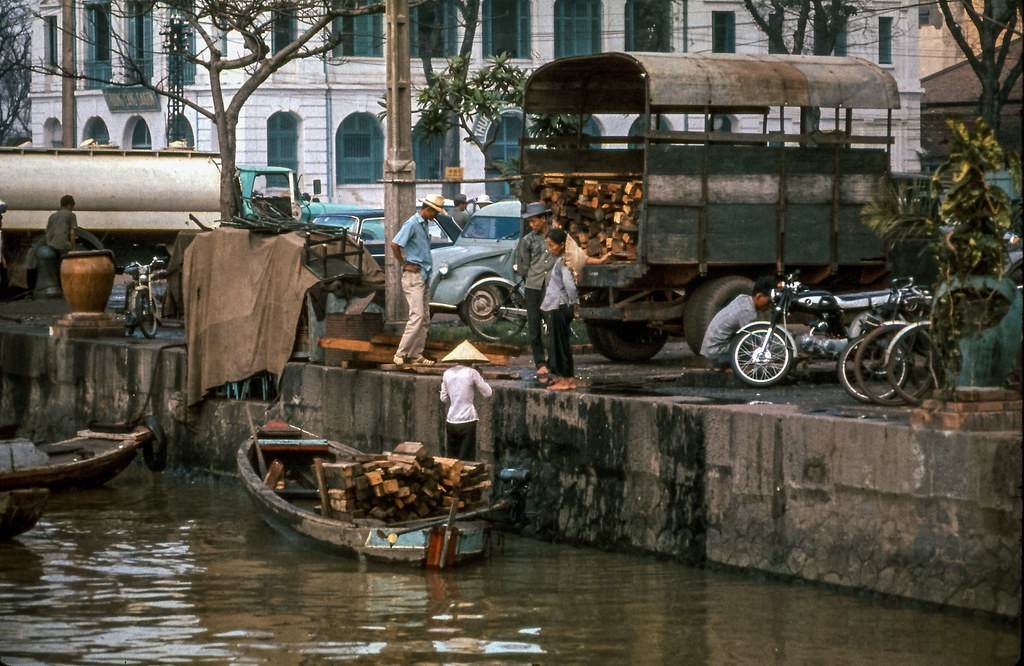 Một chiếc thuyền chỡ gỗ bốc lên xe tải ở Bến Bạch Đằng, thập niên 1960