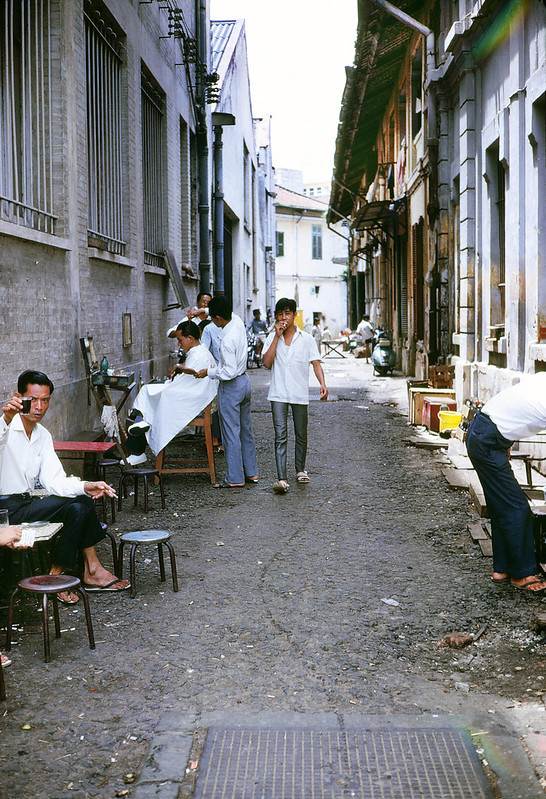 Saigon 1969. Tiệm cắt tóc và quán cà phê vỉa hè trong con hẻm thông từ đường Hàm Nghi qua Phủ Kiệt và Nguyễn Huệ